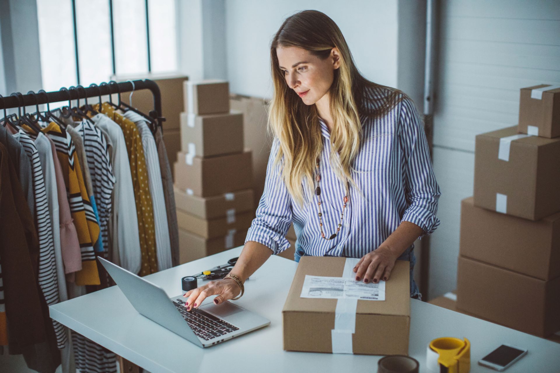 owner-of-small-business-packaging-products-and-looking-at-laptop
